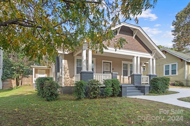 craftsman-style home featuring covered porch and a front yard