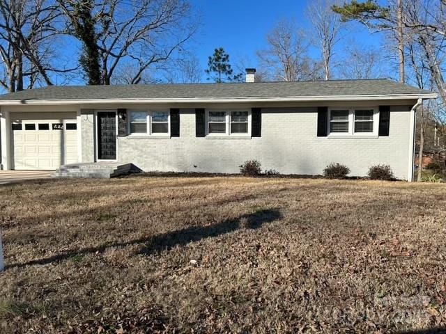 single story home with a garage and a front lawn