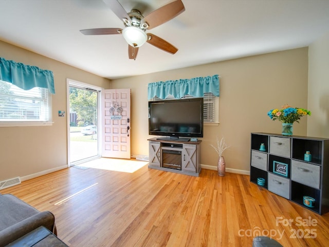 living room featuring ceiling fan and light hardwood / wood-style flooring