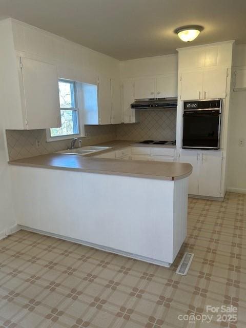 kitchen with sink, white cabinetry, and black oven