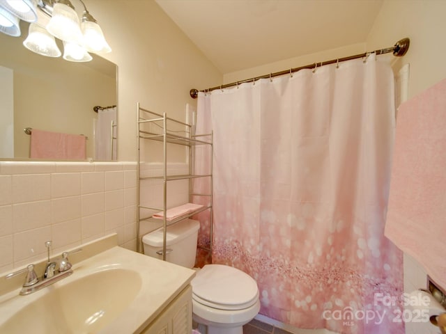 bathroom with tile walls, tasteful backsplash, toilet, walk in shower, and vanity