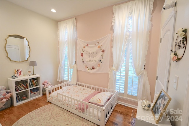 bedroom featuring wood-type flooring and multiple windows