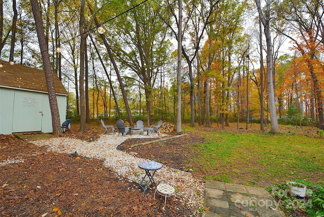 view of yard featuring a shed and an outdoor fire pit