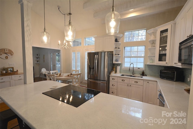 kitchen with black appliances, sink, decorative backsplash, decorative light fixtures, and white cabinetry