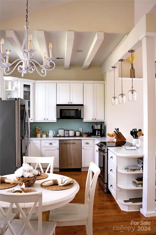 kitchen with white cabinetry, dark wood-type flooring, stainless steel appliances, and decorative light fixtures