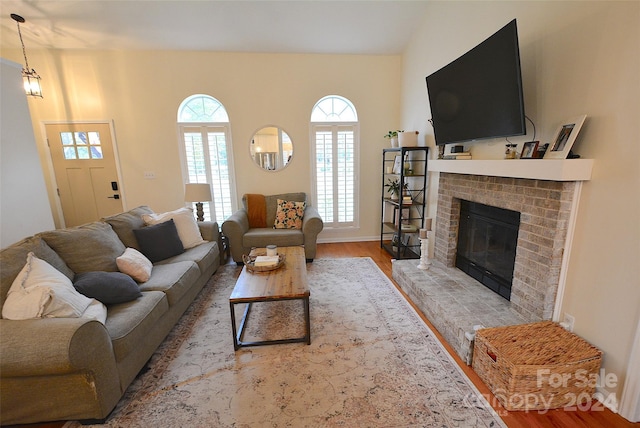 living room featuring light hardwood / wood-style floors and a brick fireplace