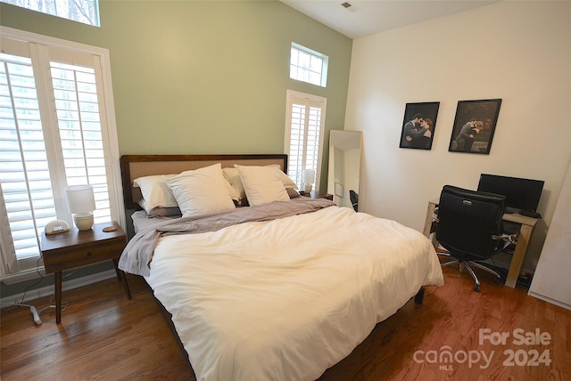 bedroom with dark hardwood / wood-style floors