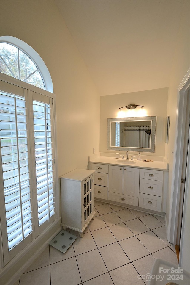 bathroom featuring tile patterned floors, vanity, and lofted ceiling