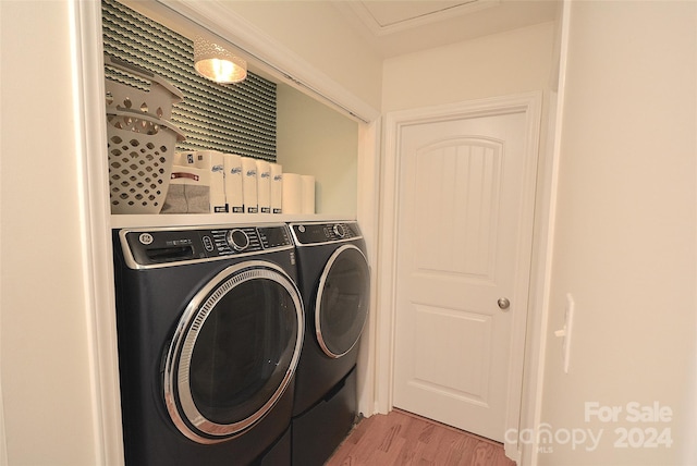 clothes washing area featuring separate washer and dryer and light hardwood / wood-style floors