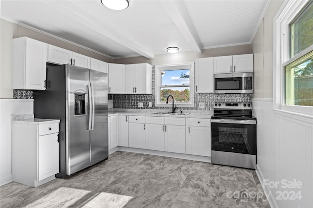 kitchen featuring backsplash, white cabinets, sink, beamed ceiling, and stainless steel appliances