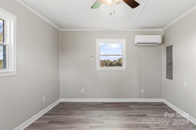 empty room featuring a wall mounted air conditioner, hardwood / wood-style floors, electric panel, and ornamental molding