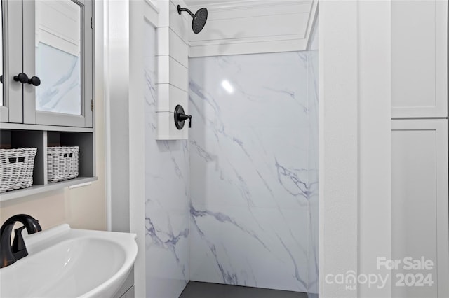 bathroom featuring tiled shower and sink