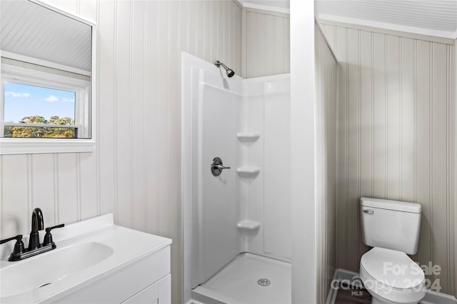 bathroom featuring vanity, toilet, a shower, and wooden walls