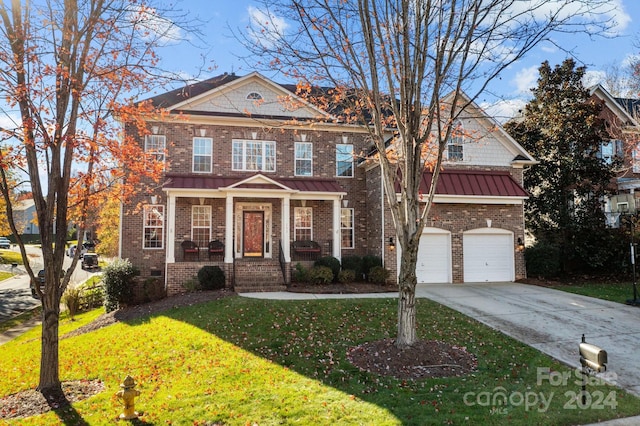 view of front of property with a front yard, a garage, and covered porch