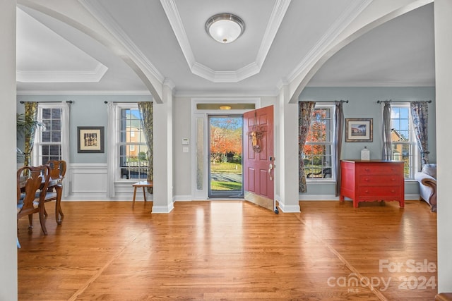 foyer entrance with plenty of natural light, wood-type flooring, and crown molding