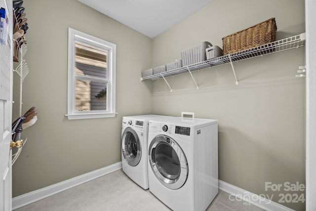 laundry room with independent washer and dryer and light tile patterned floors