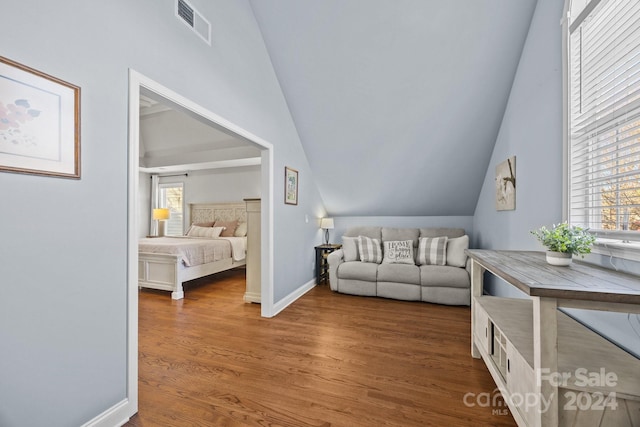 living room with hardwood / wood-style floors, a healthy amount of sunlight, and vaulted ceiling