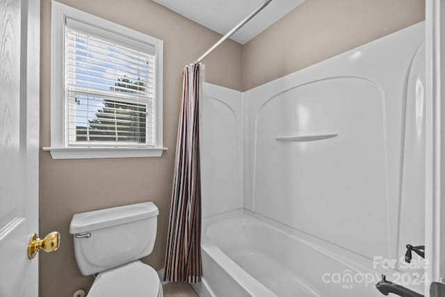 bathroom with shower / bath combo with shower curtain and toilet