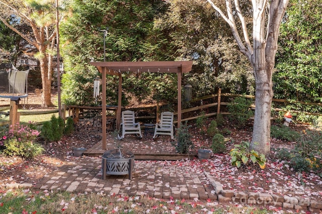 view of yard with a fire pit, a trampoline, and a patio