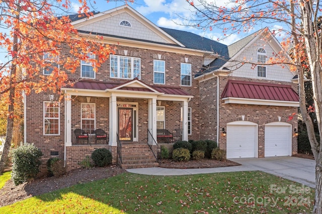 157 Montibello Dr, Mooresville, NC 28117 - view of front of home with concrete driveway, brick siding, an attached garage, and a standing seam roof