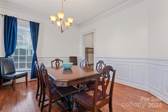 dining room with crown molding, a chandelier, and light wood-type flooring