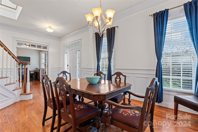 dining space featuring a chandelier, light hardwood / wood-style flooring, and crown molding