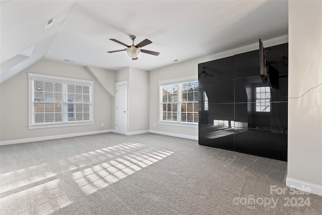 interior space featuring ceiling fan, carpet floors, and lofted ceiling