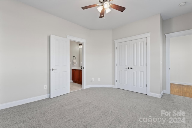 unfurnished bedroom with a closet, light colored carpet, and ceiling fan