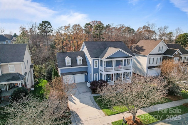 traditional-style home featuring covered porch, driveway, and a balcony