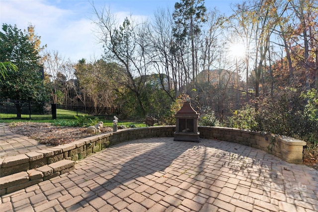 view of patio with fence and an outdoor fireplace