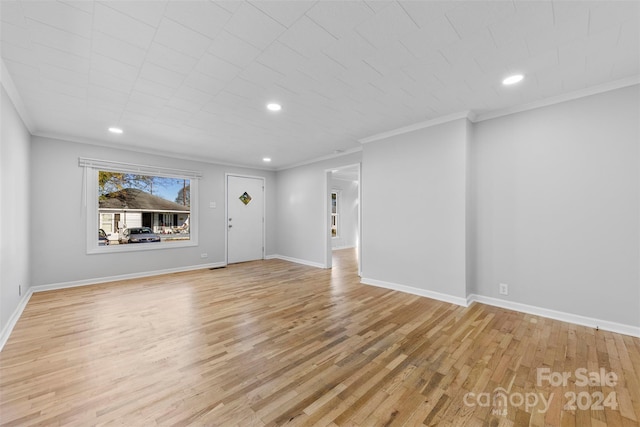 unfurnished living room with light hardwood / wood-style floors and crown molding