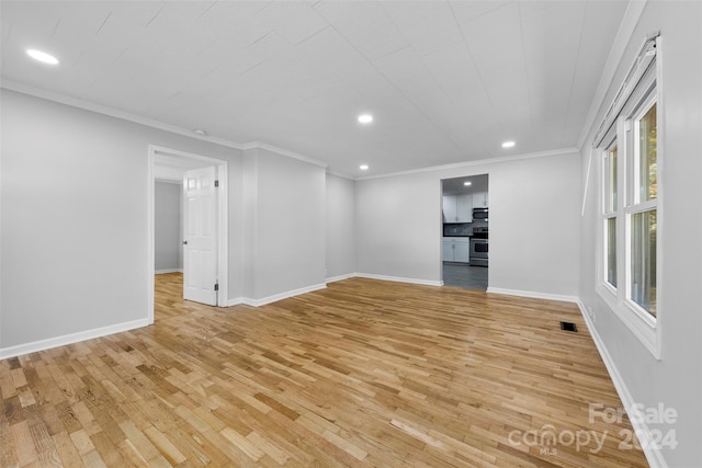 unfurnished living room featuring ornamental molding and light hardwood / wood-style flooring