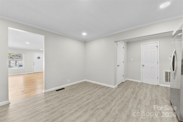 unfurnished room with crown molding and light wood-type flooring