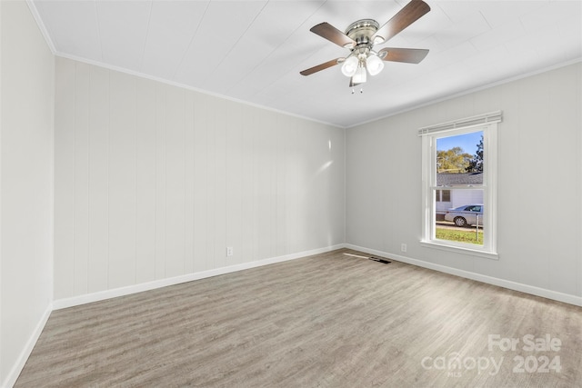 spare room with light wood-type flooring, ceiling fan, and ornamental molding