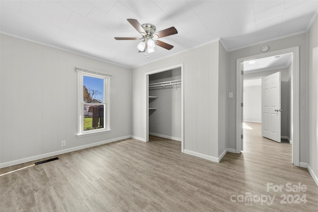 unfurnished bedroom featuring a closet, light hardwood / wood-style floors, ceiling fan, and ornamental molding