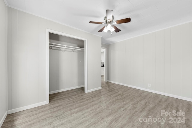 unfurnished bedroom featuring ceiling fan, a closet, ornamental molding, and light hardwood / wood-style flooring