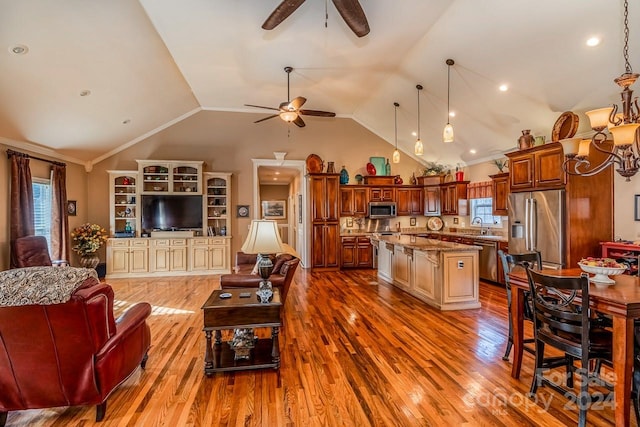 living room featuring light wood-type flooring, vaulted ceiling, and plenty of natural light