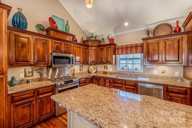 kitchen featuring sink, light stone countertops, stainless steel appliances, and ornamental molding