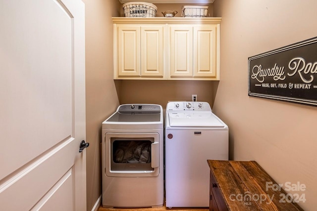 clothes washing area featuring separate washer and dryer and cabinets