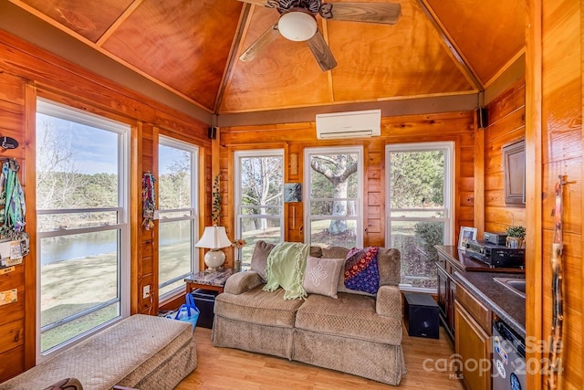 sunroom / solarium featuring vaulted ceiling, plenty of natural light, and an AC wall unit