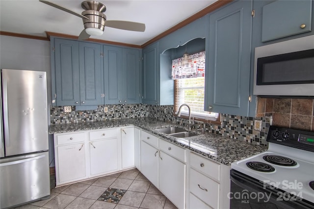 kitchen with blue cabinetry, sink, tasteful backsplash, white cabinets, and appliances with stainless steel finishes