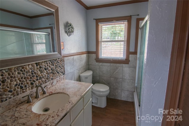 bathroom featuring hardwood / wood-style floors, vanity, crown molding, toilet, and tile walls