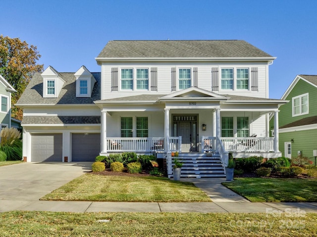 view of front of home with a garage, a front yard, and a porch