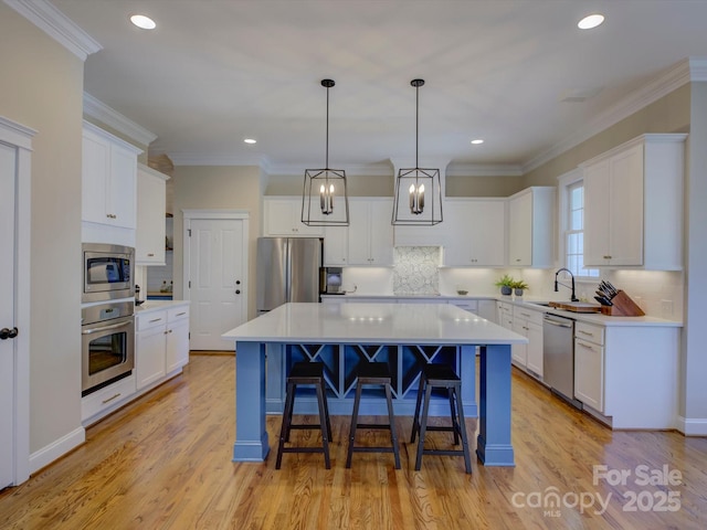 kitchen featuring stainless steel appliances, a center island, and white cabinets