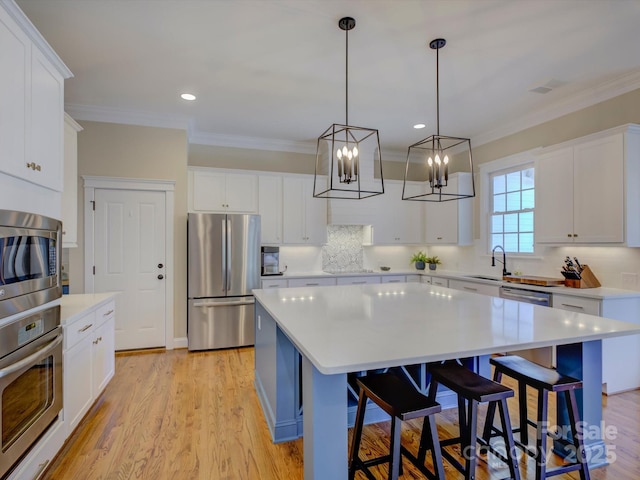 kitchen featuring white cabinetry, stainless steel appliances, and a center island