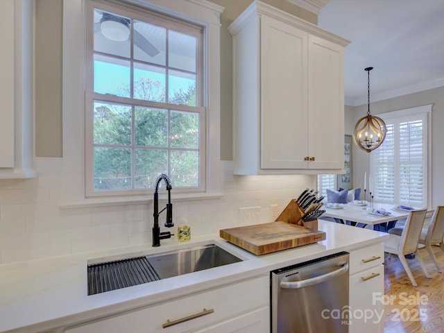 kitchen featuring dishwasher, sink, backsplash, white cabinets, and ornamental molding