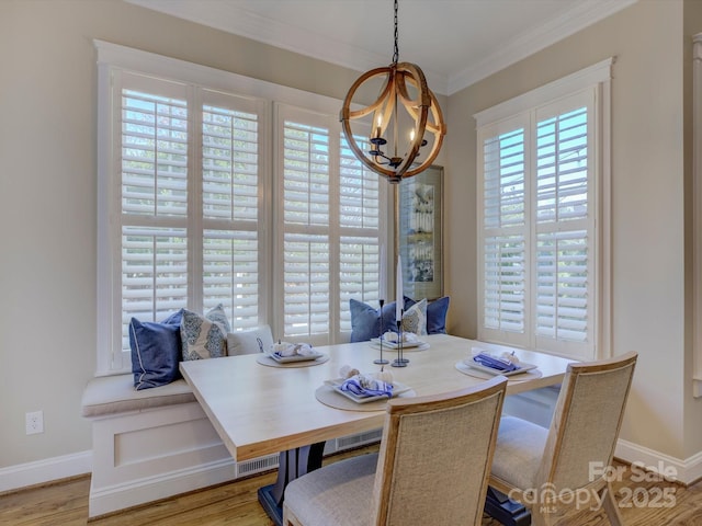 dining area with an inviting chandelier, ornamental molding, and light hardwood / wood-style flooring