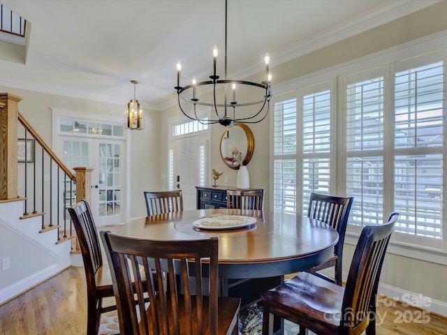 dining space featuring crown molding, a notable chandelier, light hardwood / wood-style floors, and a wealth of natural light