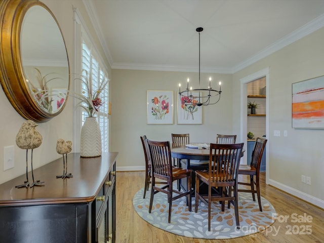 dining area featuring ornamental molding, a chandelier, and light hardwood / wood-style flooring