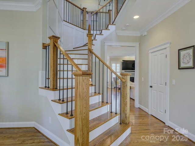 stairs featuring crown molding and hardwood / wood-style floors